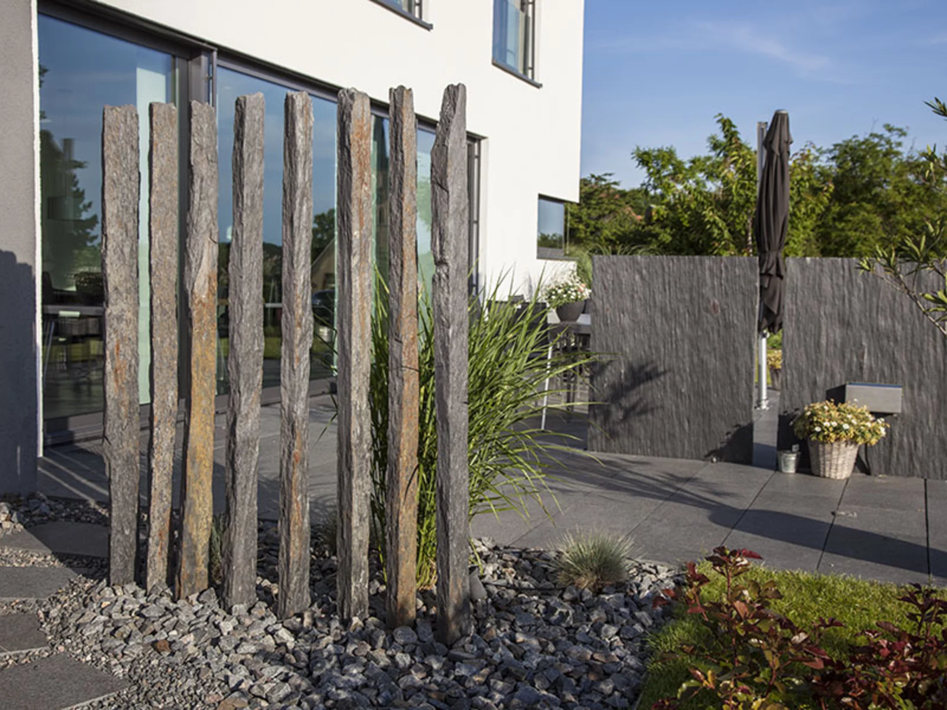 Im Garten von Haus Rademacher finden sich unterschiedliche Steinelemente, die als Sichtschutz dienen (Foto: © BAUMEISTER-HAUS)