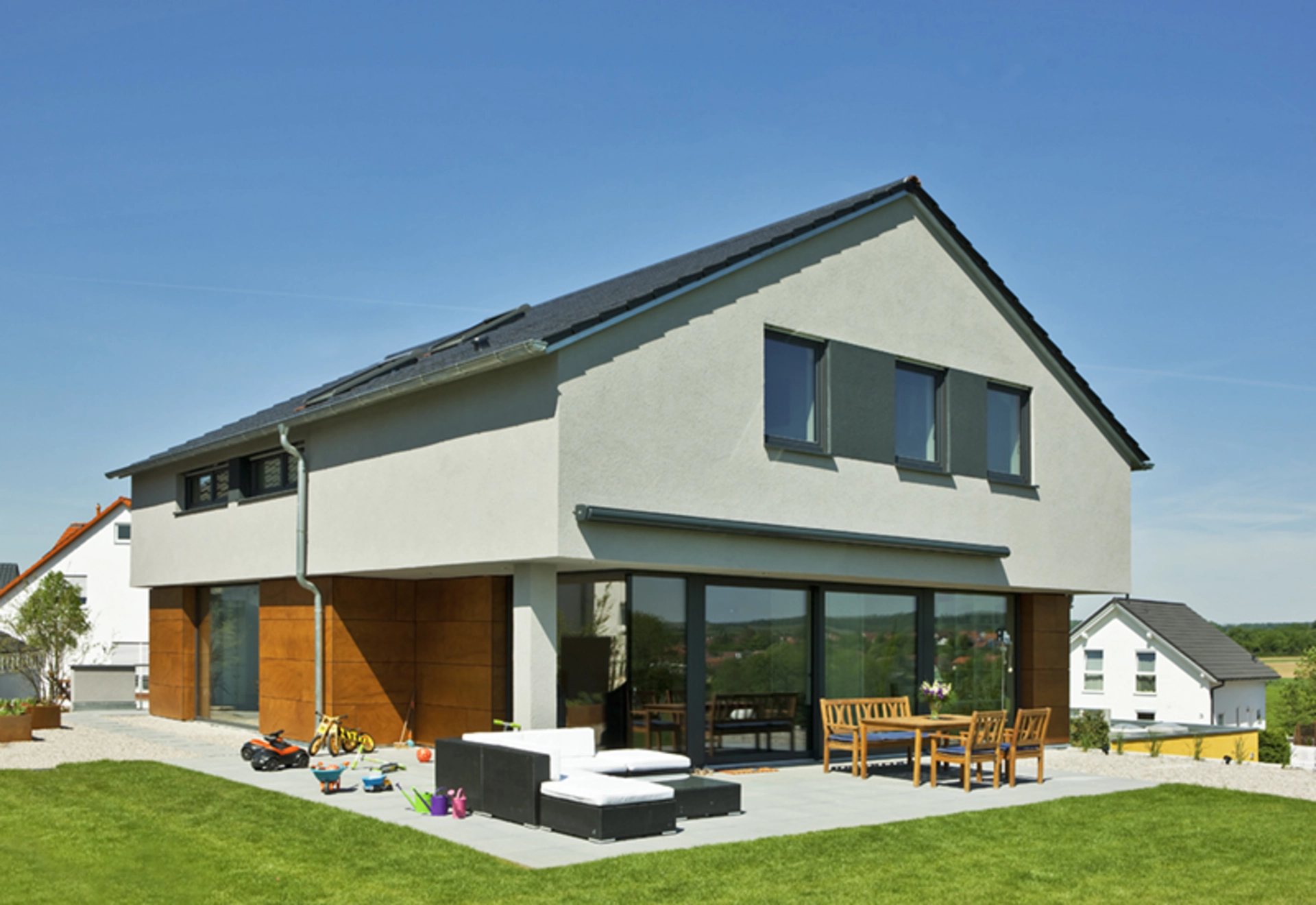 Haus Ohlig mit Fassadenplatten in Holzoptik und Panoramafenstern im Erdgeschoss und Putzfassade im Obergeschoss (Foto: BAUMEISTER-HAUS)