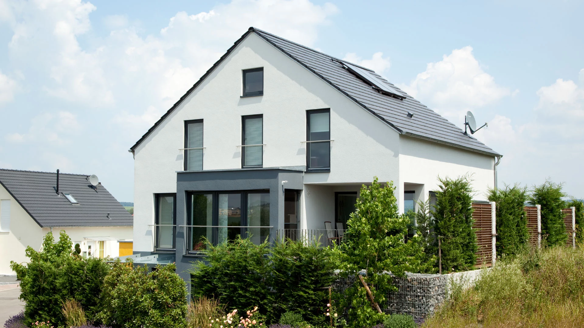 Die Hanglage des Hauses Hoffmann ermöglicht nicht nur einen wundervollen Ausblick, sondern auch eine helle Einliegerwohnung mit eigener Terrasse im Untergeschoss. (Foto: © BAUMEISTER-HAUS)