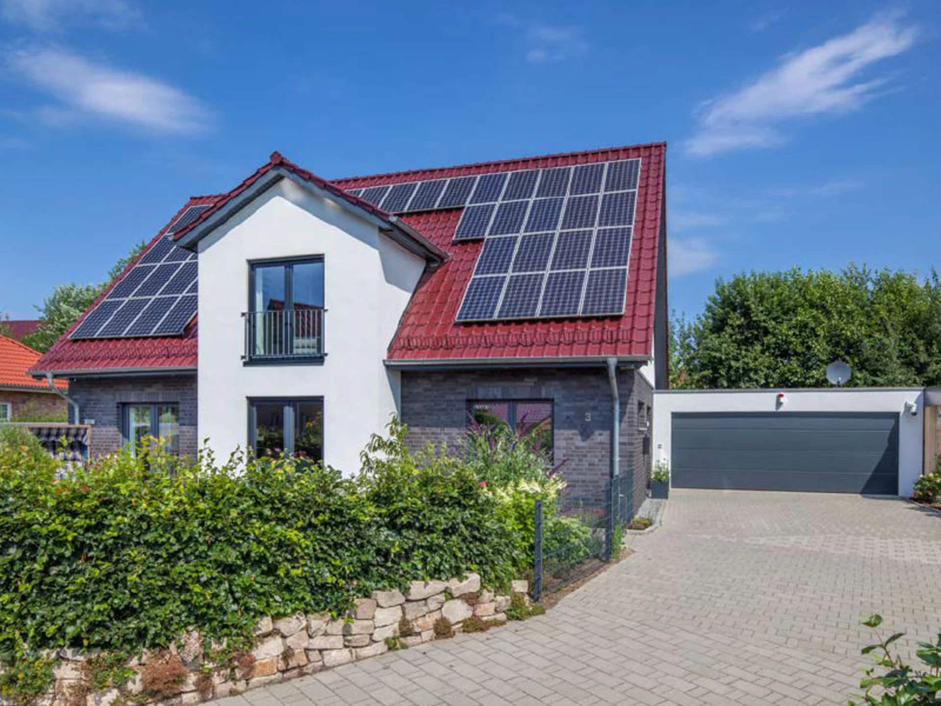 Auch die Familie des Hauses Zander weiß, wie die heimische Privatsphäre mit viel Grün geschützt werden kann und zeigt eine einfache Hecke mit darunterliegenden, geschmackvollen Steinblöcken. (Foto: BAUMEISTER-HAUS)