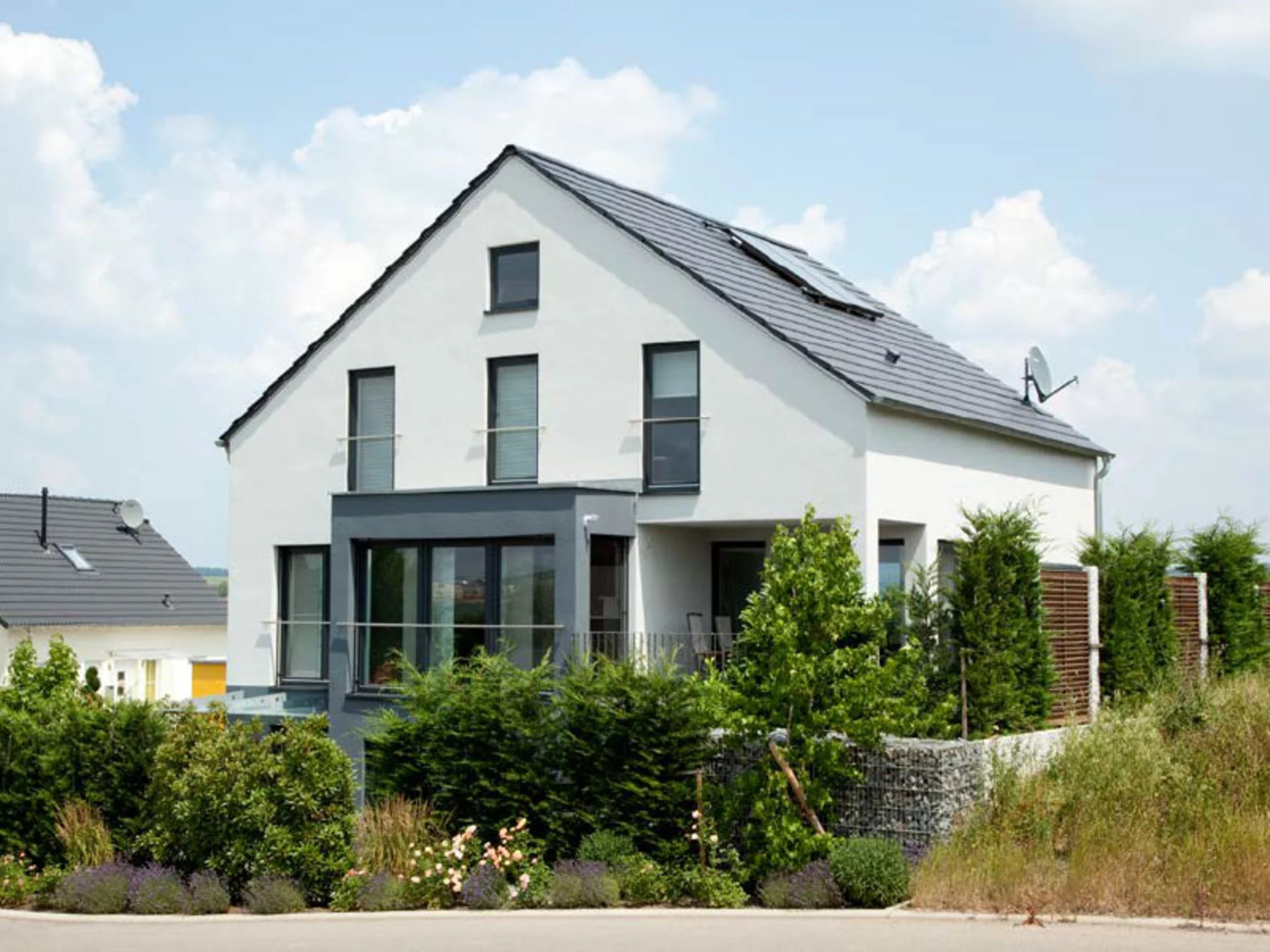 Auch ein Mix aus verschiedenen Hecken und Pflanzenarten kann den Garten, wie bei Haus Hoffmann, alle Blicke auf sich ziehen lassen. (Foto: BAUMEISTER-HAUS)